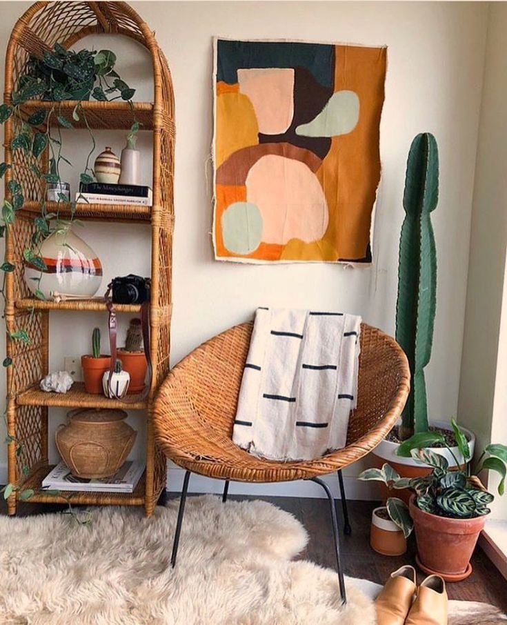 modern bohemian bookshelf with books, handmade ceramics, plants, and vintage decor