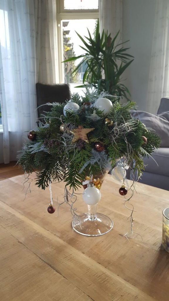 how to decorate your home for Christmas console table decorated with an evergreen garland, ceramic vase, and subtle ornaments