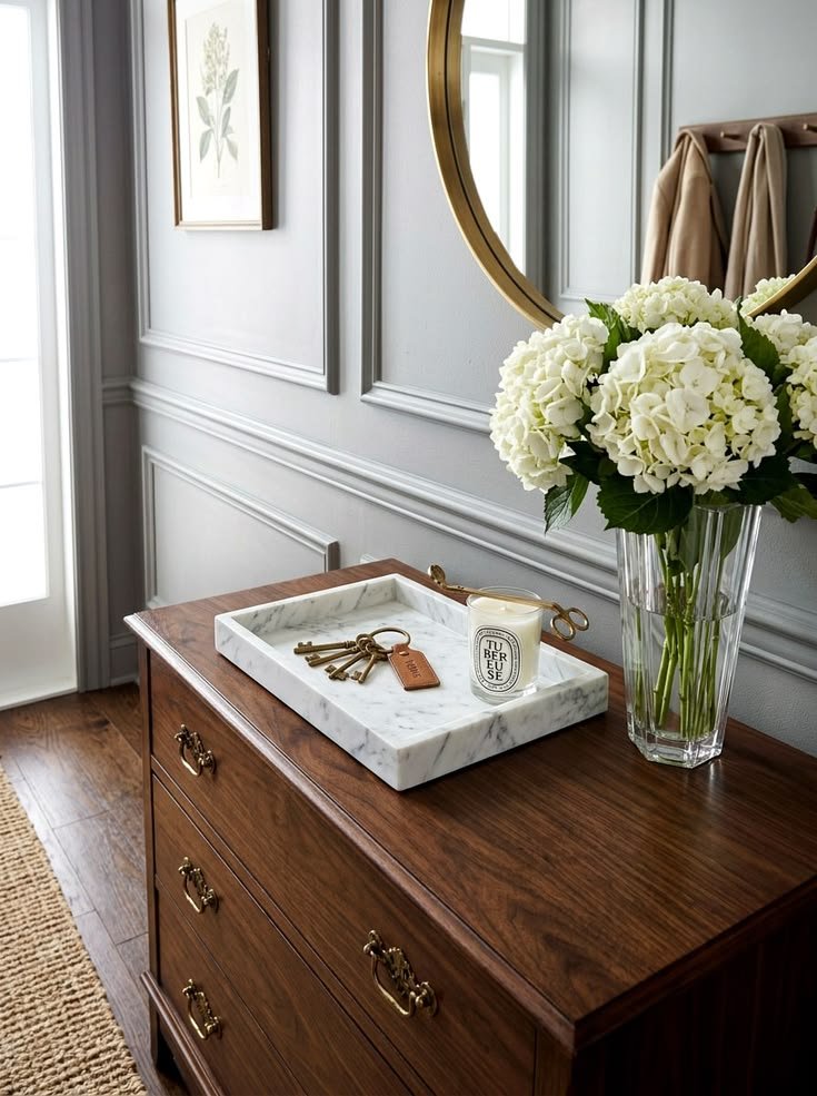 Decorative catchall tray styled on a cozy entryway table