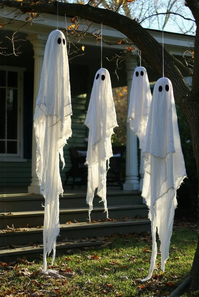 Handmade cheesecloth ghost decorations on a Halloween mantel