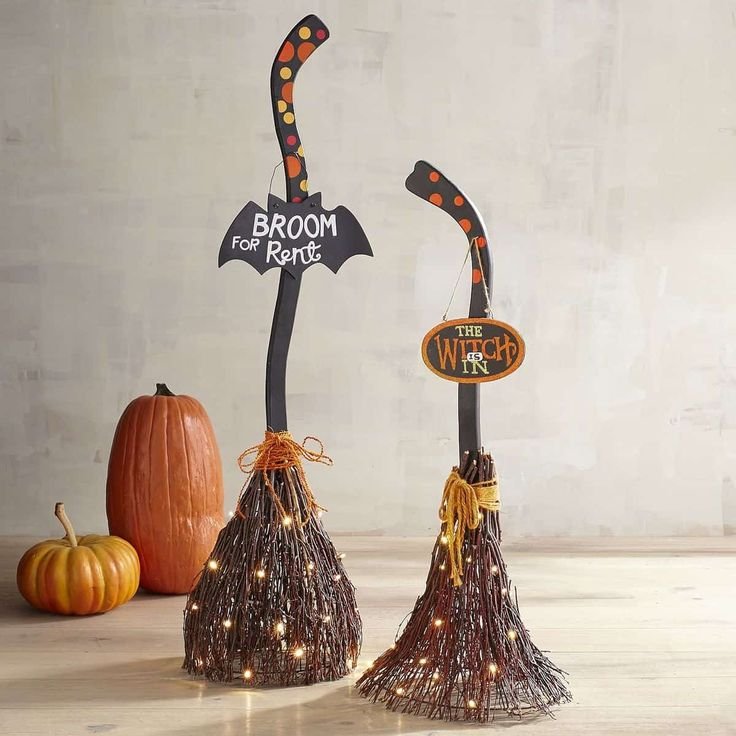 Mini handmade witch brooms in a ceramic vase