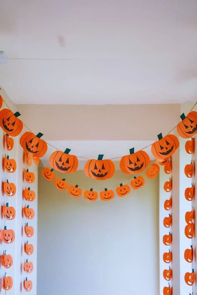 Paper pumpkin garland in a stylish Halloween dining room