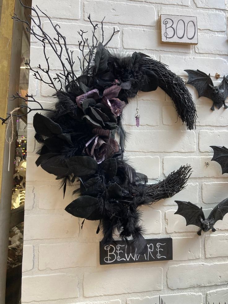 Crescent moon Halloween wreath decorated with black bats and lavender flowers.