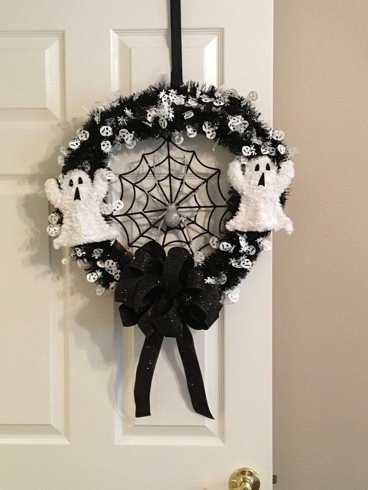 Cute Halloween ghost wreath with white fabric ghosts and miniature orange pumpkins.