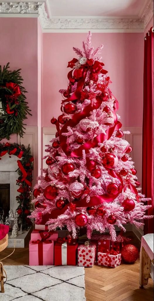 Pink and red Christmas tree with velvet bows, glossy ornaments and heart decorations.