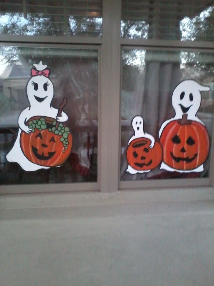 Cute ghost holding a pumpkin painted on a glass window