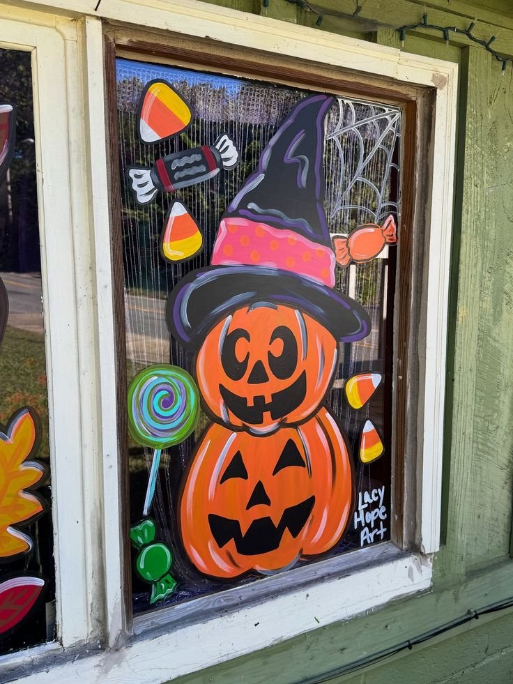 Colorful jack-o'-lantern window painting with smiling pumpkins