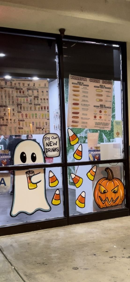 Colorful candy corn painted on a kitchen window for Halloween