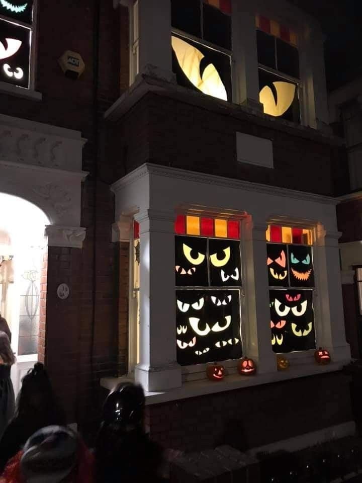 Colorful monster eyes painted on a dark Halloween window