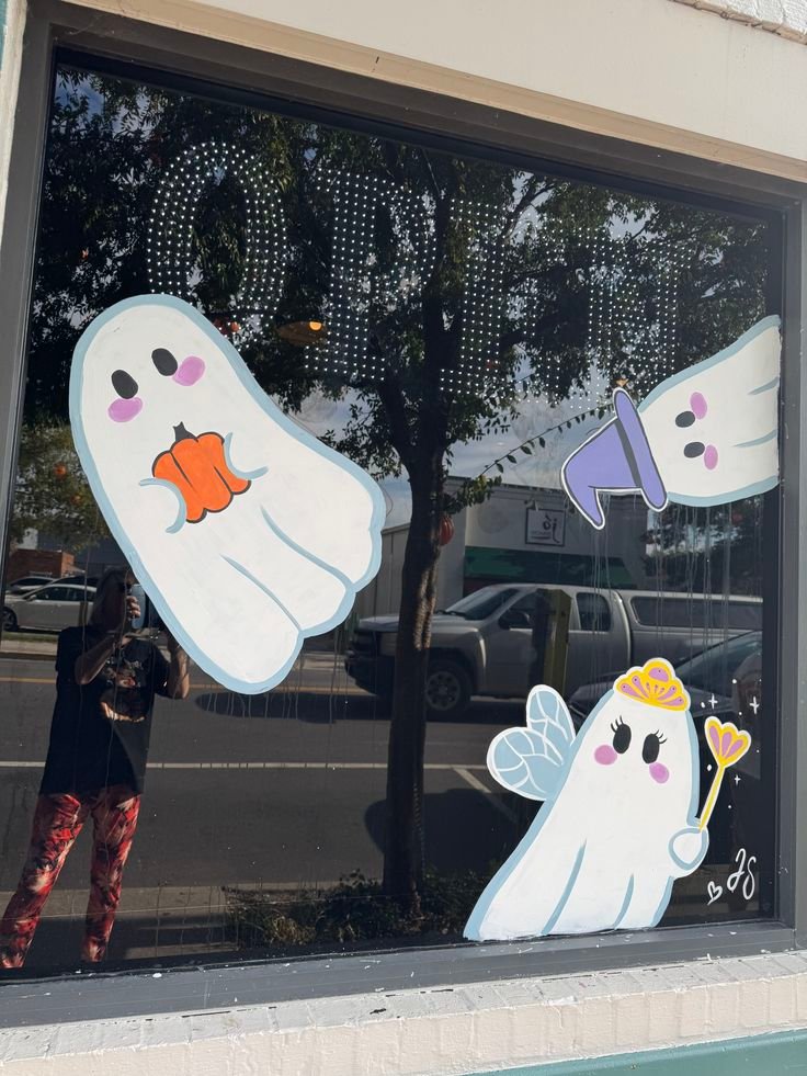Cute white ghosts painted on a Halloween window painting ideas