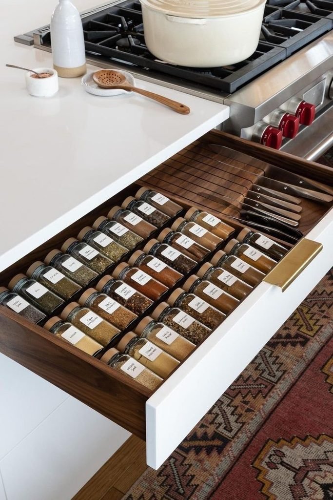 Organized kitchen spice drawer with neatly arranged spice jars
