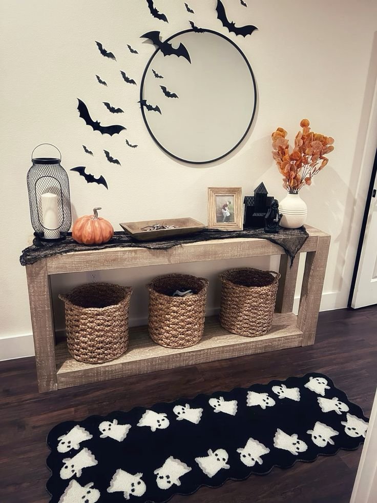 Antique hallway mirror surrounded by flying black bats above a narrow Halloween console.