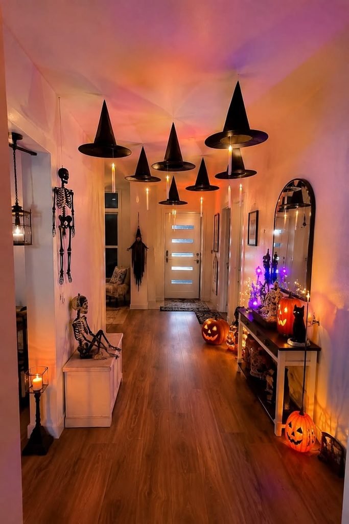 Floating black witch hats with velvet ribbons decorating a Halloween hallway wall.