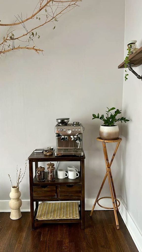 Small apartment coffee station with a narrow cabinet, compact espresso machine, mugs, and vertical wall storage