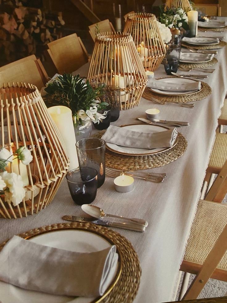 Layered Thanksgiving place setting with a woven charger, ceramic plates, linen napkin, and glassware.