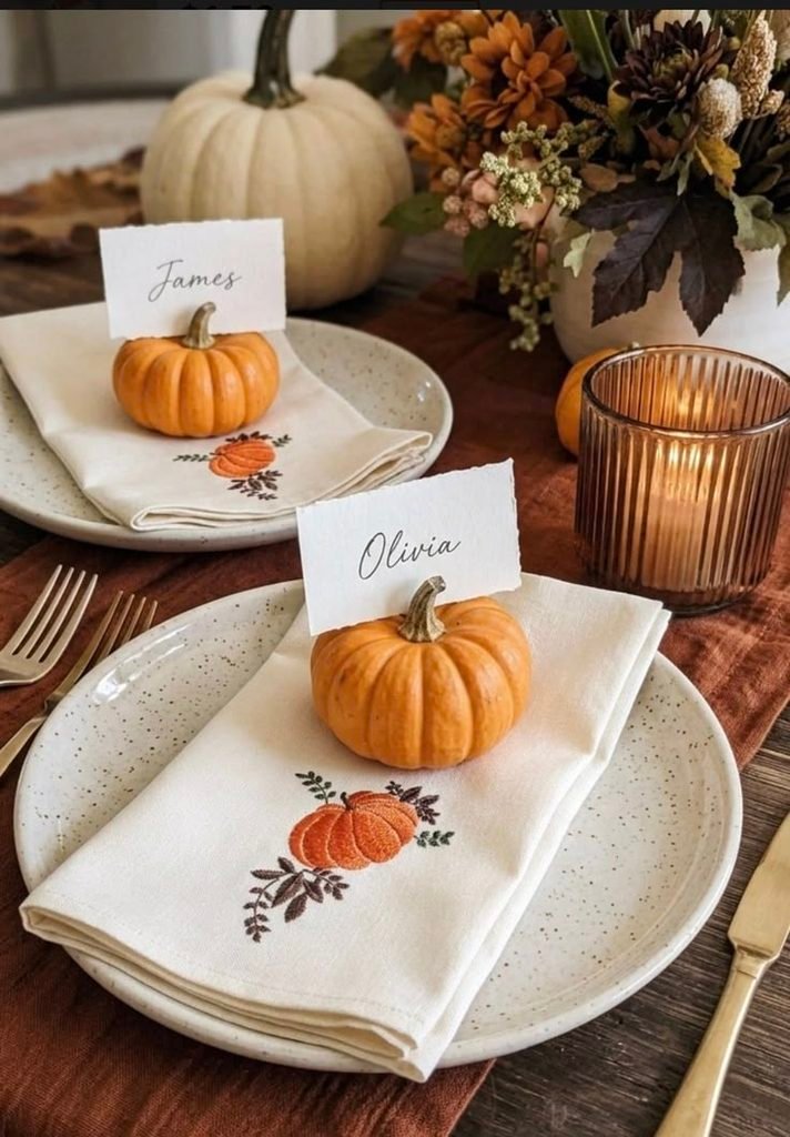 Thanksgiving place settings decorated with individual mini ceramic vases and seasonal foliage.