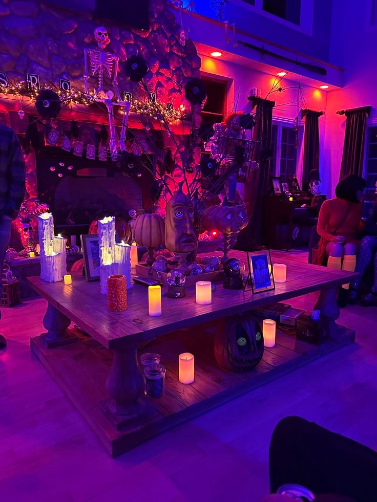 Halloween party living room with moody lighting, dark cushions, bat decorations, and warm seasonal accents.