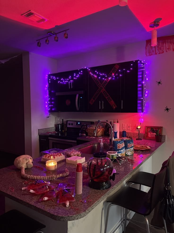 Halloween kitchen island styled with a serving tray, seasonal treats, pumpkins, and decorative branches.