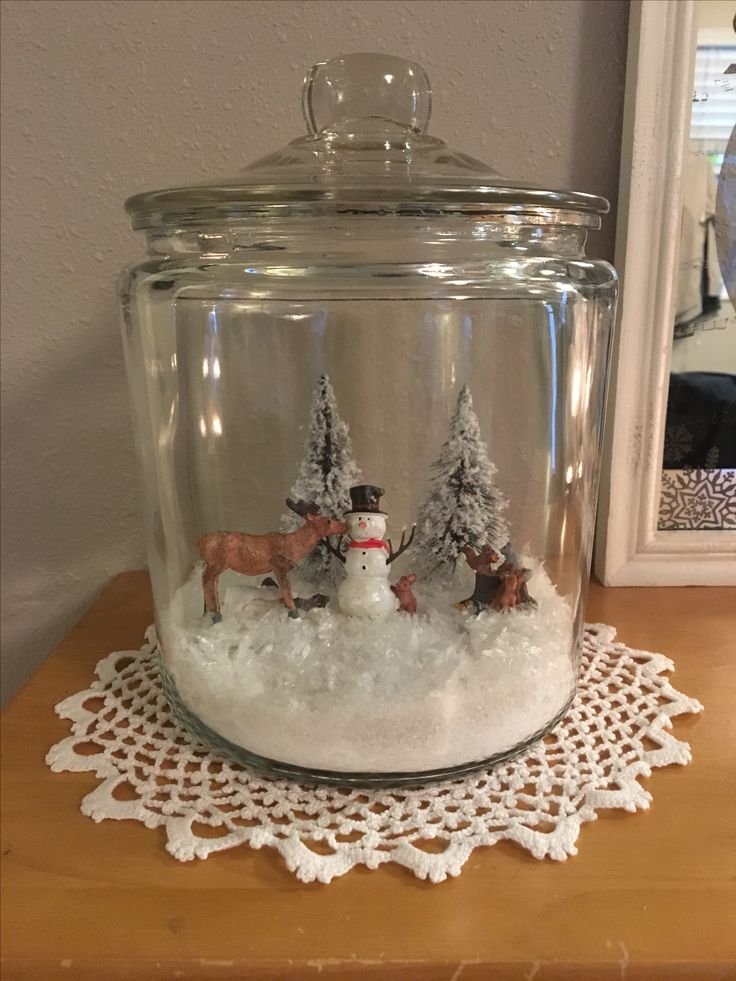 Frosted mason jar Christmas centerpiece with evergreen branches, white berries, and silver accents.