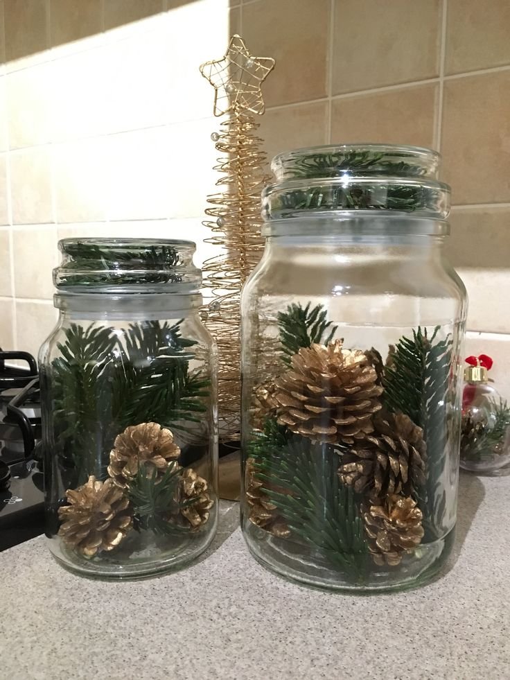 Christmas mason jars filled with cranberries, water, and evergreen sprigs.