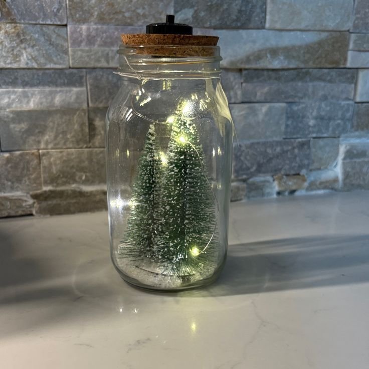 christmas mason jar centerpiece ideas with tiny ornaments on a holiday table.