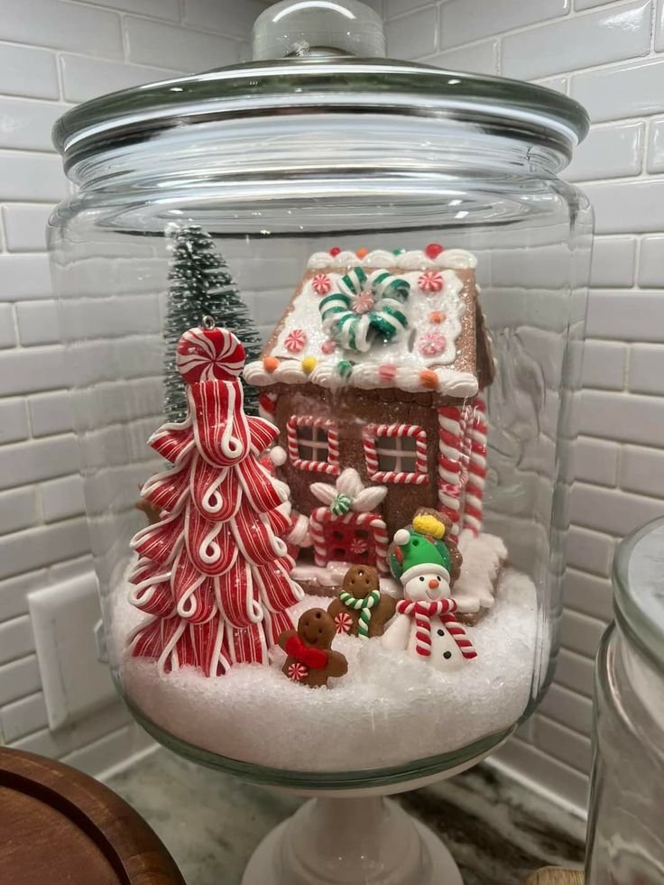 Gingerbread-inspired Christmas mason jar centerpiece with cinnamon, dried orange, greenery, and red ribbon.