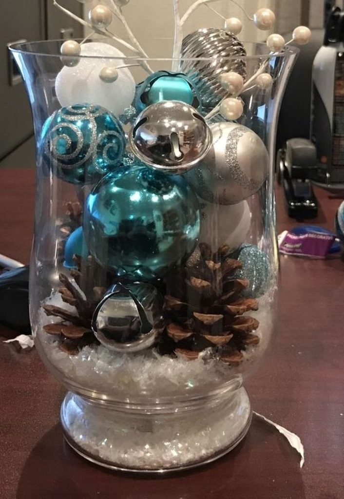 Midnight blue and silver Christmas mason jar centerpiece with frosted greenery and silver ornaments.