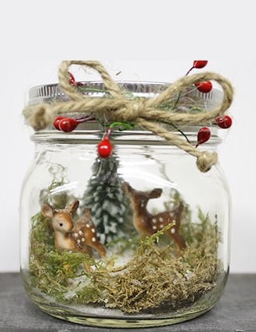 Woodland Christmas mason jar centerpiece with pine branches, pinecones, berries, and wooden ornaments.