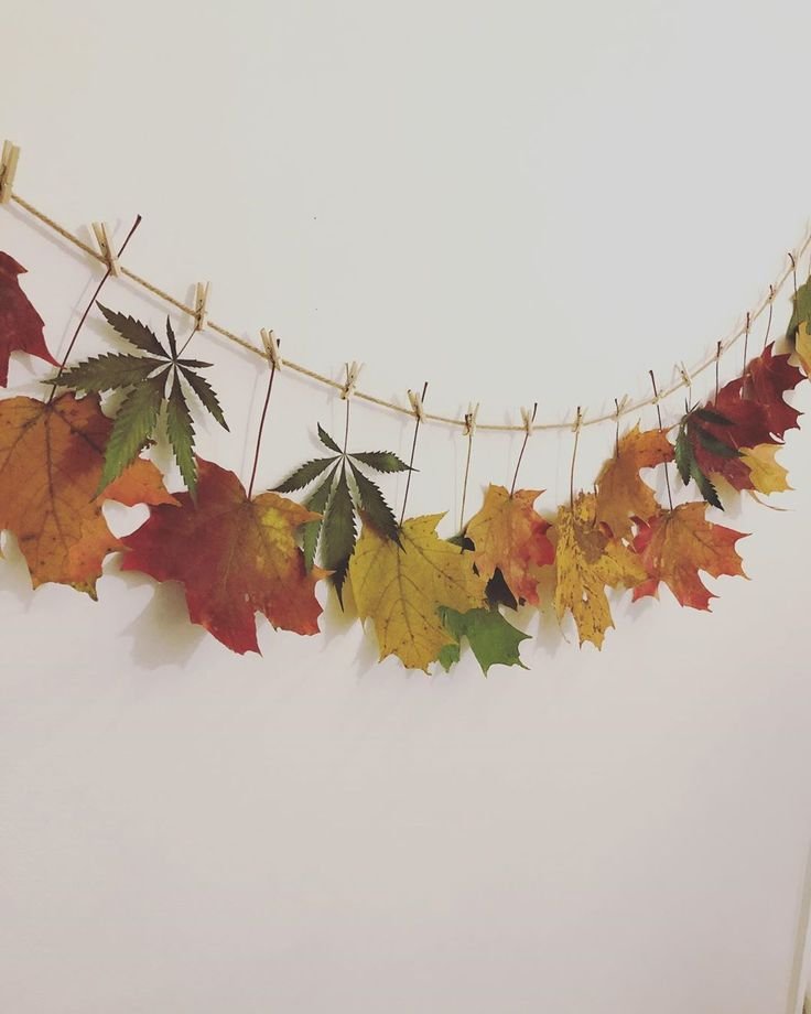 Dried autumn leaf garland decorating a cozy Thanksgiving mantel