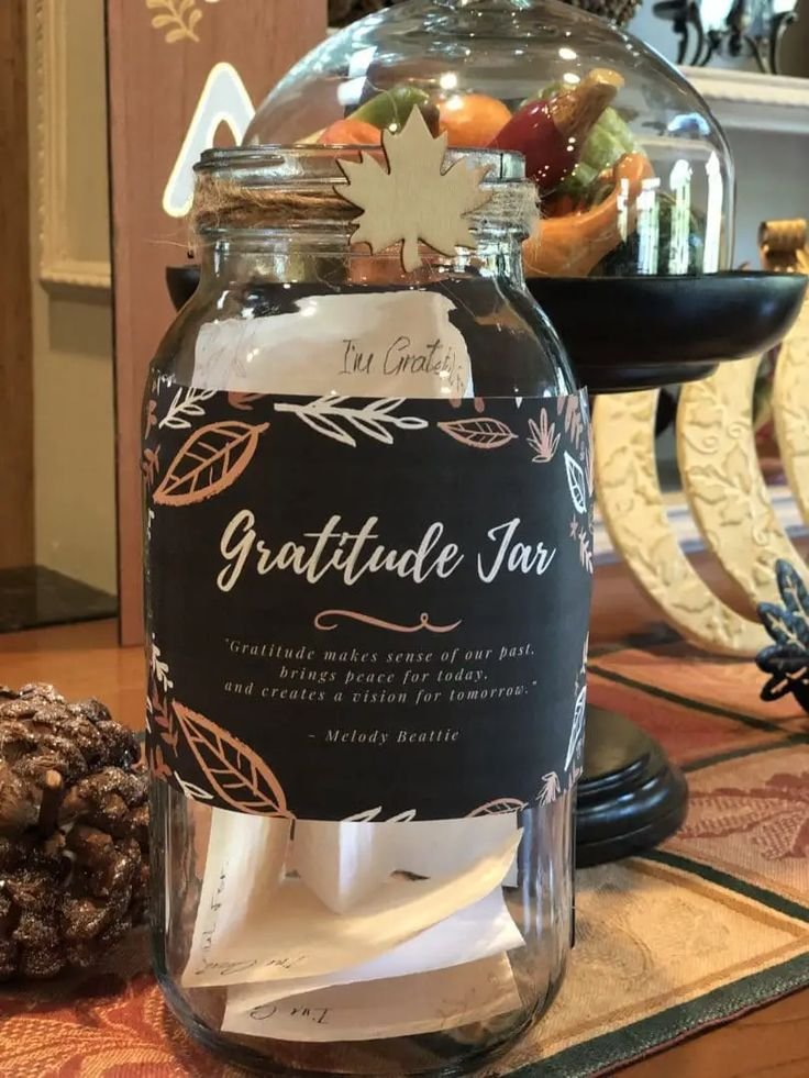 Thanksgiving gratitude memory jar surrounded by pumpkins and autumn decor