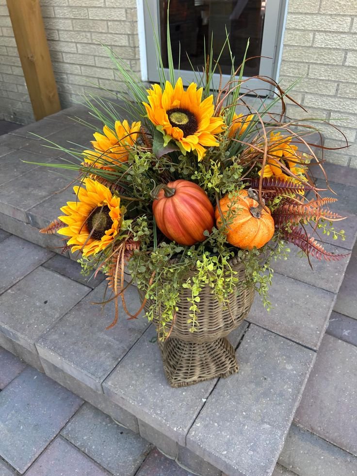 Woven basket filled with pumpkins, wheat, and foliage on a Thanksgiving porch