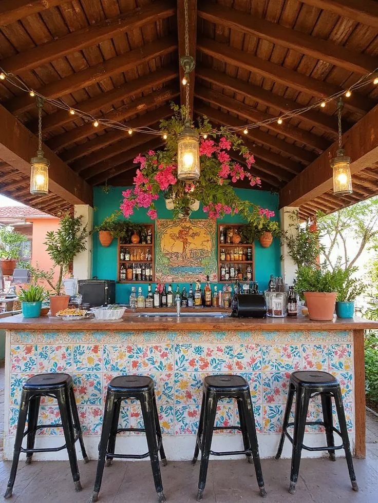Colorful tiled outdoor bar with a wooden countertop and painted stools in a Mexican-inspired backyard.