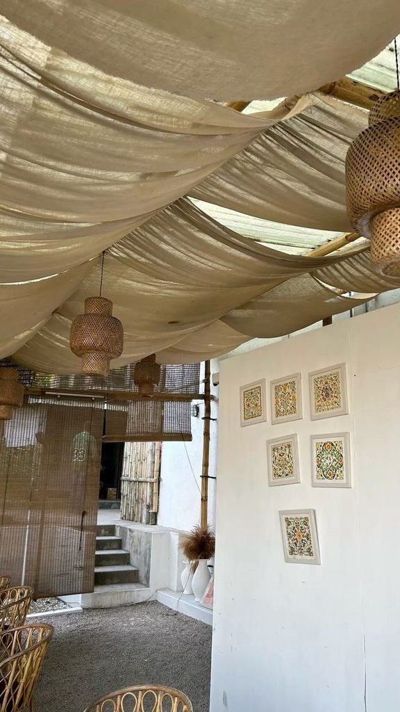 Oatmeal linen-look fabric draped above a rustic bedroom with oak furniture and cream bedding