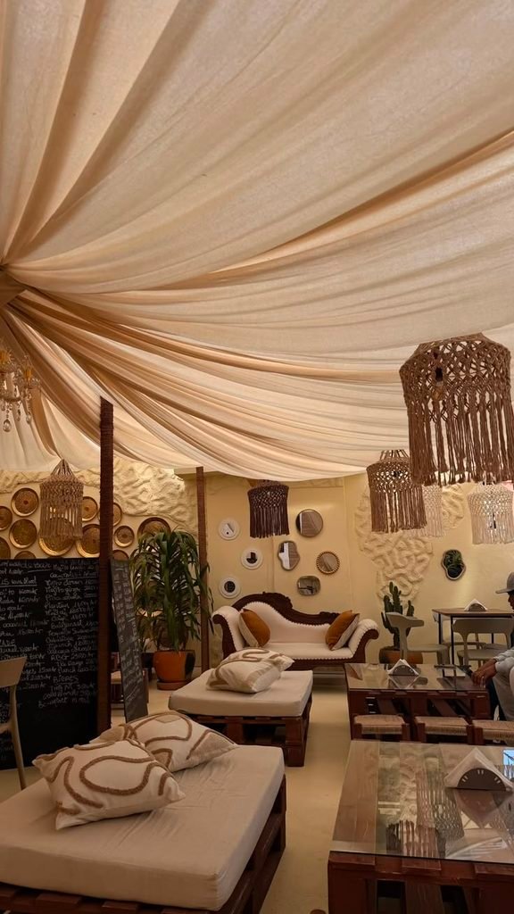 Neutral beige fabric ceiling ideas draping above a modern organic living room with natural wood accents.