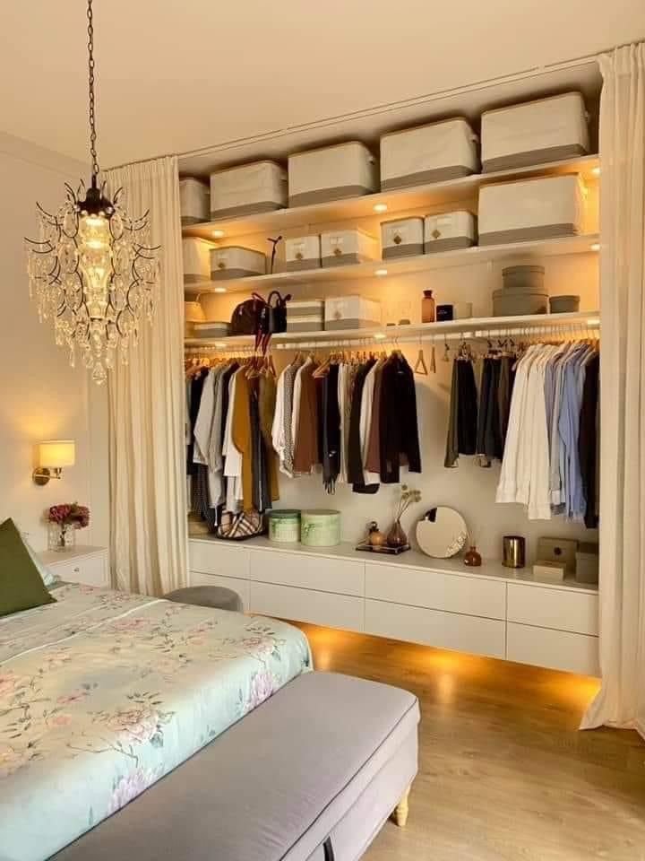 Modern open wardrobe with hanging clothes, folded sweaters, and accessible shoe shelves.