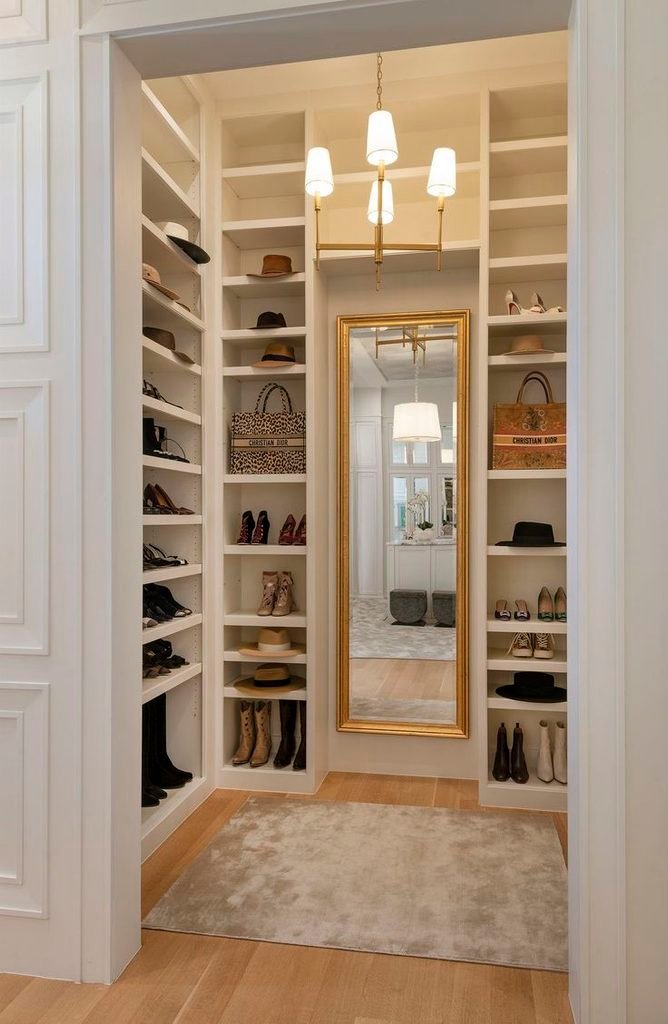 Arched full-length mirror beside a wardrobe in a bright dressing area.