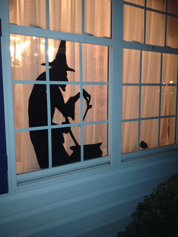 Black witch silhouette Halloween decoration displayed in an exterior window