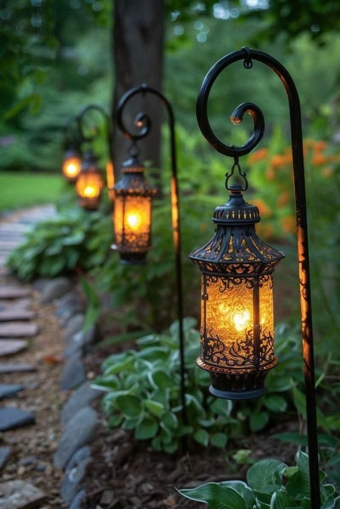 Black outdoor lanterns with warm lights lining a Halloween garden walkway