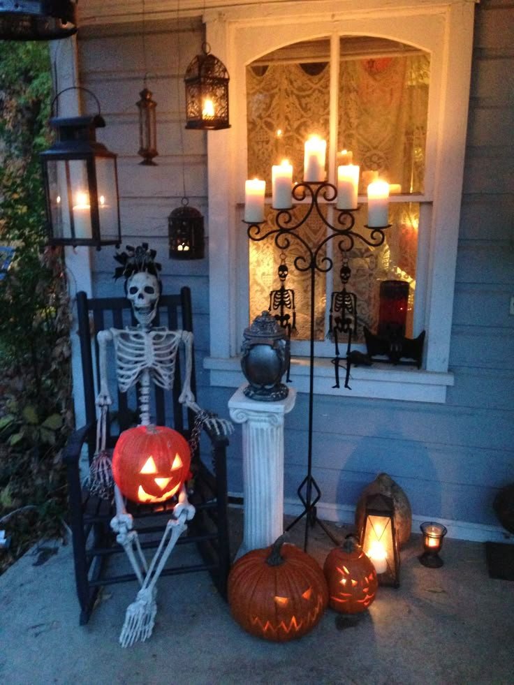 Cozy outdoor Halloween seating area with pumpkins, a black lantern, and a crow decoration.