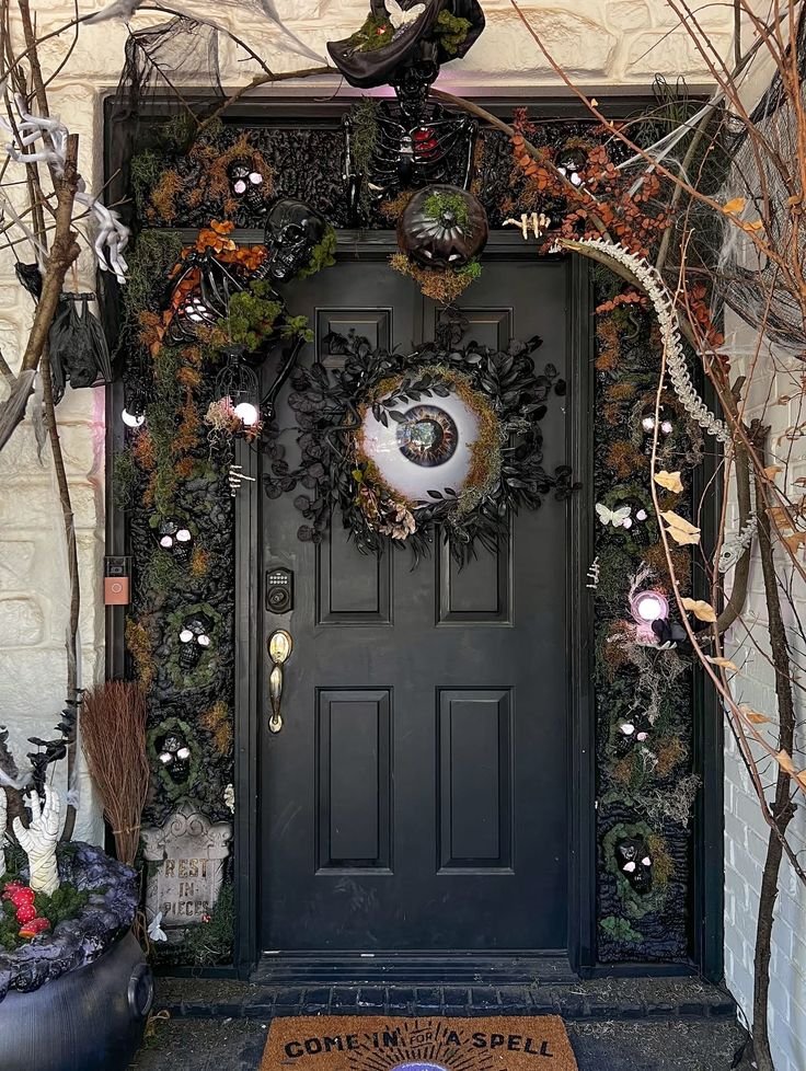 Layered outdoor Halloween entrance with pumpkins, lanterns, ghosts, and bats.